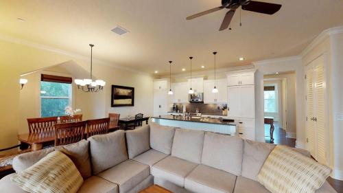 a living room with a large couch and a kitchen at F211 Second Floor 3-bedroom Poolside Lanai in Koloa