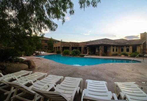 a group of white lounge chairs next to a swimming pool at Coral Vista Suite Resort Pools BBQ Fireplace Jacuzzi Tub A9 in Washington