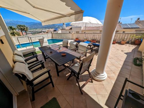 un patio con mesa, sillas y piscina en Viña Home, en Torre del Mar