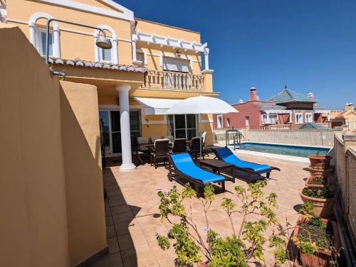 a house with a patio with chairs and an umbrella at Viña Home in Torre del Mar