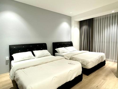Armadale Residence 3R3B@GalaCity في كوتشينغ: سريرين في غرفة الفندق ذات شراشف بيضاء