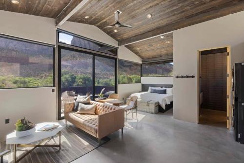 salon z kanapą, łóżkiem i oknami w obiekcie Zion loft with canyon views - unit 3 w mieście Springdale