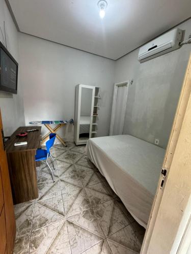 a bedroom with a bed and a desk and a table at Condomínio Alencar in Parauapebas
