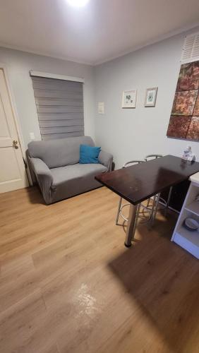 ein Wohnzimmer mit einem Sofa und einem Tisch in der Unterkunft Apartamento Estocolmo I in Valdivia