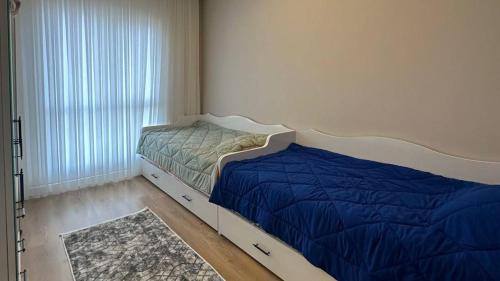 een slaapkamer met een bed met blauwe lakens en een raam bij 53 Fully Equipped VIP Apartment near Başakşehir in Avcılar