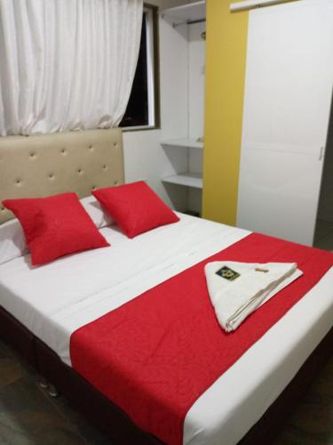 a bedroom with a bed with red pillows at Hotel Oiba Alfa Plaza in Oiba