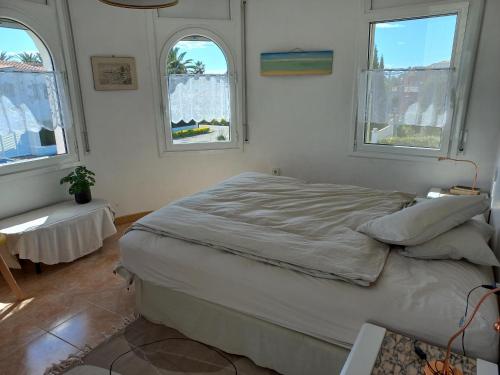 1 Schlafzimmer mit einem großen Bett und 2 Fenstern in der Unterkunft Casa Sant Pere Pescador, 4 dormitorios, 7 personas - ES-89-116 in Sant Pere Pescador