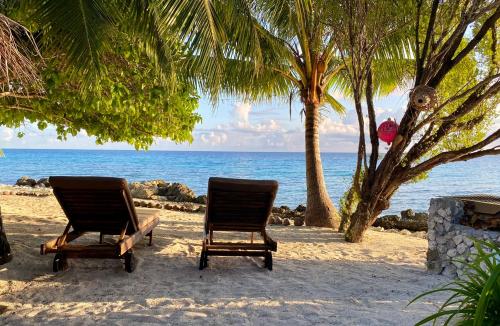 two chairs sitting on the beach near the ocean at Rangiroa Sunny House in Avatoru