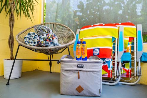 a chair and a basket of toys next to a chair and a towel at Mid-Century 1bd House - Beach Gear - 5min Walk to Beach in Clearwater Beach