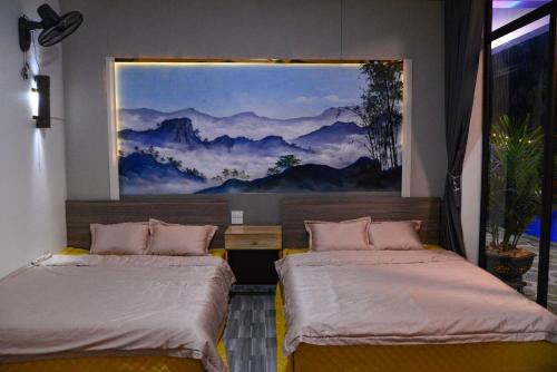 a bedroom with two beds and a painting on the wall at Phúc Hưng Kazin Homestay Ba vì in Ba Vì
