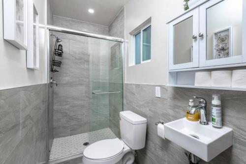 La salle de bains est pourvue d'une douche, de toilettes et d'un lavabo. dans l'établissement Chic and Spacious 3BR Gem in Central LA, à Los Angeles