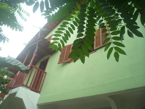 a building with brown shuttered windows and a tree at Casa da Dona Dita in Paraty