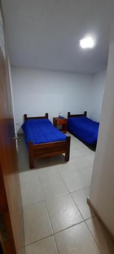 una camera con due letti con lenzuola blu sopra di Complejo Caroya a Colonia Caroya