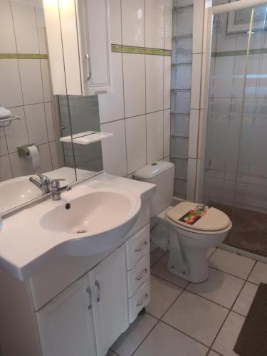 Baño blanco con lavabo y aseo en Pagerie bas de villa en Les Trois-Îlets