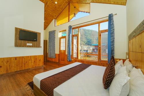 a bedroom with a bed and a large window at Orchard Heaven in Manāli