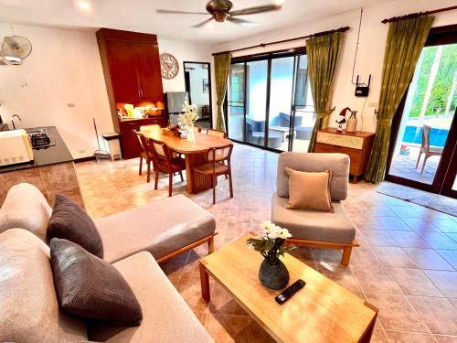 a living room with a couch and a table at Villa Malee in Thai Muang