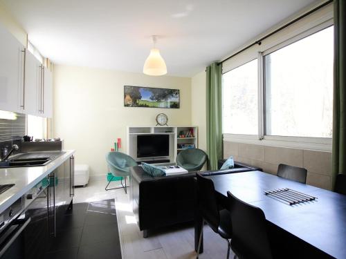 une cuisine et un salon avec une table et une salle à manger dans l'établissement T3 duplex avec parking privatif à 100m du centre, proche thermes, wifi, équipé, max 5 pers, La Bourboule - FR-1-608-269, à La Bourboule