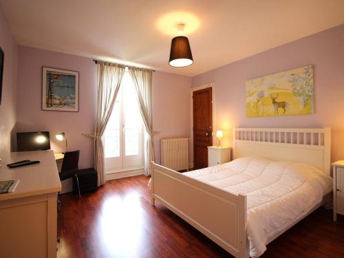 - une chambre avec un lit blanc, un bureau et une fenêtre dans l'établissement T3 duplex avec parking privatif à 100m du centre, proche thermes, wifi, équipé, max 5 pers, La Bourboule - FR-1-608-269, à La Bourboule