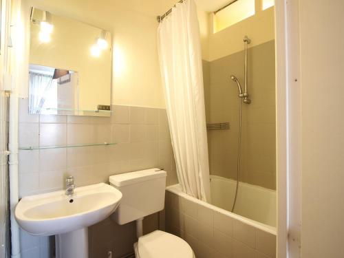 une salle de bain avec un lavabo, des toilettes et une douche dans l'établissement T3 duplex avec parking privatif à 100m du centre, proche thermes, wifi, équipé, max 5 pers, La Bourboule - FR-1-608-269, à La Bourboule