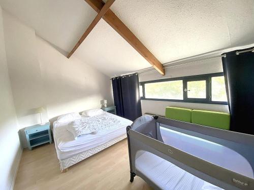 une petite chambre avec un lit et une fenêtre dans l'établissement Duplex avec Terrasse, à 250 m de la Plage du Fogeo et Proche Commerces - FR-1-639-114, à Arzon