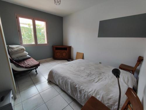 um quarto com uma cama, uma cadeira e uma janela em Villa Saint-André, 3 pièces, 6 personnes - FR-1-776-89 em Saint-André