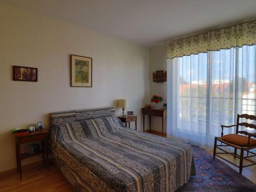 1 dormitorio con cama, ventana y silla en Appartement Royan, 3 pièces, 3 personnes - FR-1-494-182, en Royan