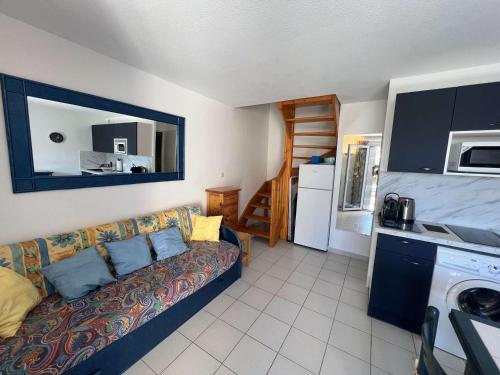 un salon avec un canapé et une cuisine dans l'établissement Pavillon cosy, proche plage et commerces, pour 6 pers., avec terrasse, garage et équipements modernes - FR-1-701-80, à Valras-Plage