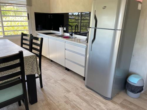 une cuisine avec un réfrigérateur en acier inoxydable et une table dans l'établissement Las Pirquitas Villa Giardino, à Huerta Grande