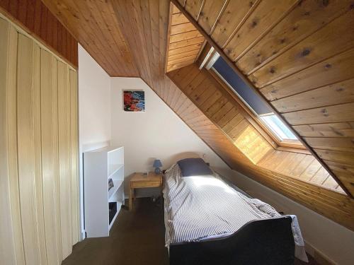 une chambre avec un lit et un plafond en bois dans l'établissement Maison cosy près de la plage de Kerfontaine, idéale pour 3 personnes avec jardin et parking - FR-1-639-113, à Sarzeau