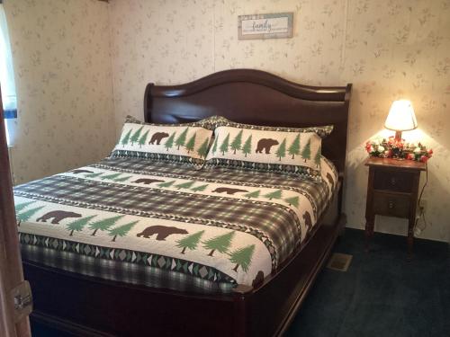 a bedroom with a bed with a blanket and pillows at Smokey Mountain Overlook in Bryson City