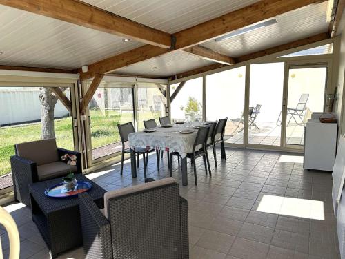une salle à manger avec une table et des chaises dans l'établissement Maison de plain-pied avec jardin clos, véranda, terrasse et barbecue, près de St Gilles Croix de Vie - FR-1-224-811, à Le Fenouiller