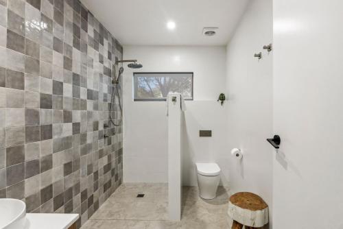 a white bathroom with a toilet and a shower at Ice 3 in Thredbo