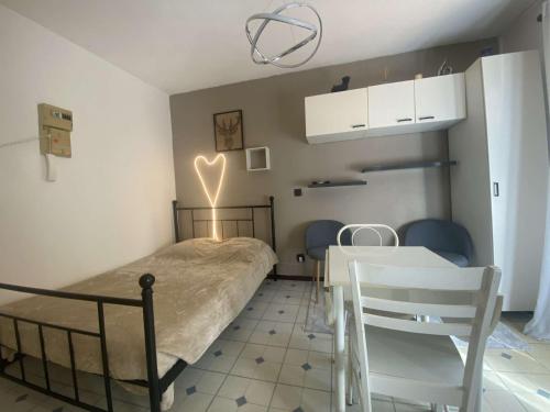 1 dormitorio con 1 cama, mesa y sillas en Studio Amélie-les-Bains-Palalda, 1 pièce, 2 personnes - FR-1-659-98, en Amélie-les-Bains-Palalda