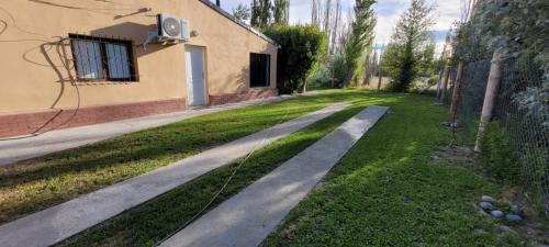 a path in a yard next to a house at La linfancia in Perito Moreno