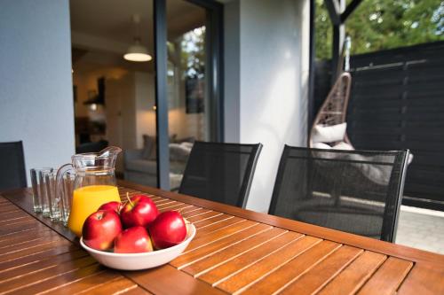 a bowl of apples and a glass of orange juice on a table at Lipowy Zakątek - domki blisko Energylandii i stacji PKP w Zatorze in Zator