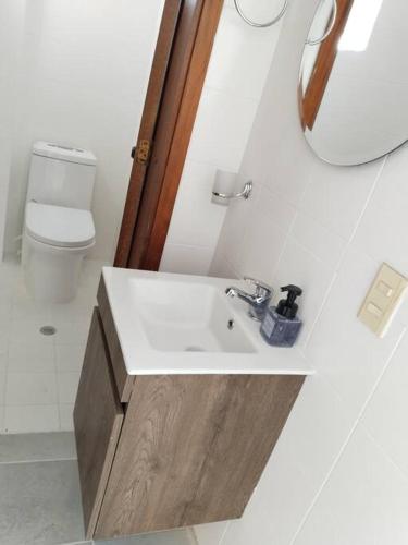 a bathroom with a sink and a toilet and a mirror at Encantadora Casa, Calima Darién in Darién