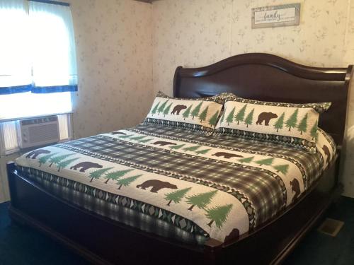 un letto con coperta e cuscini sopra di Smokey Mountain Overlook a Bryson City