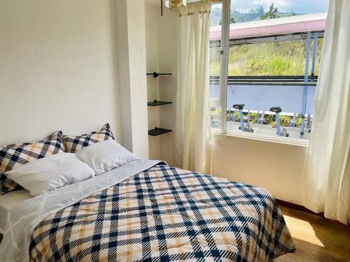a bedroom with a bed and a large window at ¡Fogata y Lujo! in Ambato