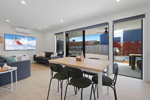 a dining room and living room with a table and chairs at Pool Side Point Oasis - Plunge Pool in Sanctuary Point