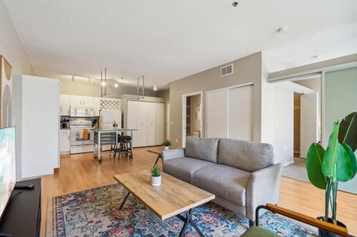 a living room with a couch and a table at CozySuites Mill District with pool, gym #01 in Minneapolis