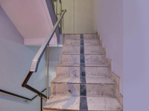 een trap in een gebouw met een metalen leuning bij Super OYO Flagship Hotel Iris Lite in New Delhi