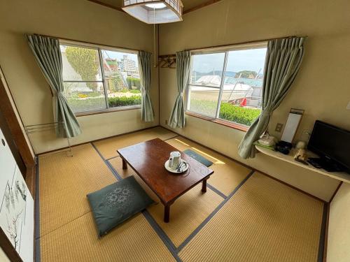 sala de estar con mesa y 2 ventanas en Irifune, en Tonosho