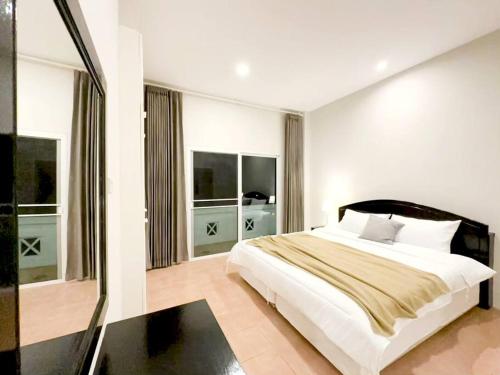 a bedroom with a large bed and two windows at Prime Hill , Kathu Phuket / E3 in Phuket Town