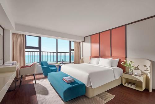 Habitación de hotel con cama, escritorio y sillas en Vias Hotel Vung Tau - Inclusive Transportation en Vung Tau