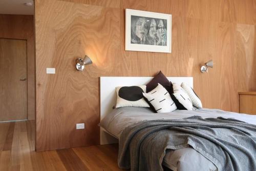 a bedroom with a large bed with wooden walls at Rye Glass House - Architectural Escape in Rye