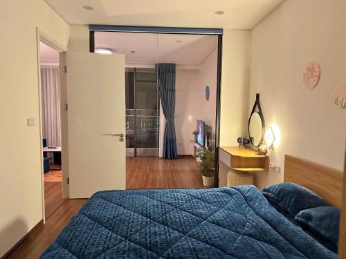 ein Schlafzimmer mit einem blauen Bett und einem Spiegel in der Unterkunft Green Diamond Homestay in Hạ Long