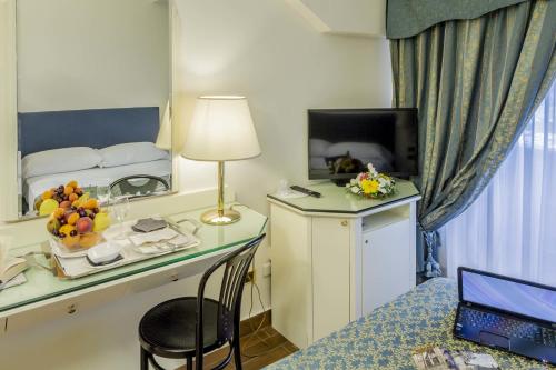 a room with a desk with a laptop and a bed at Grande Albergo Potenza in Potenza