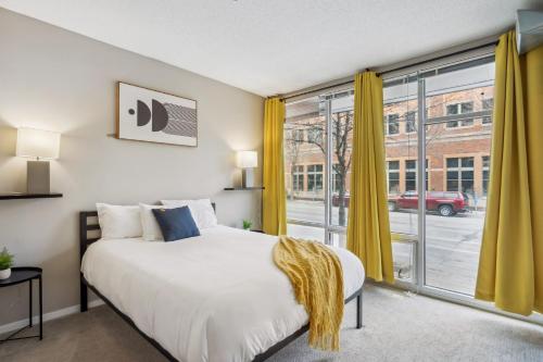 a bedroom with a bed and a large window at CozySuites Mill District pool gym # 02 in Minneapolis