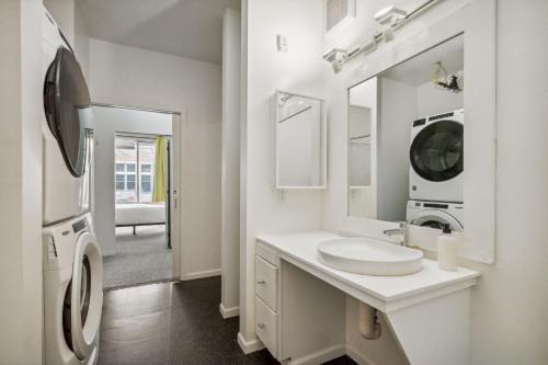 a white bathroom with a sink and a mirror at CozySuites Mill District pool gym # 02 in Minneapolis