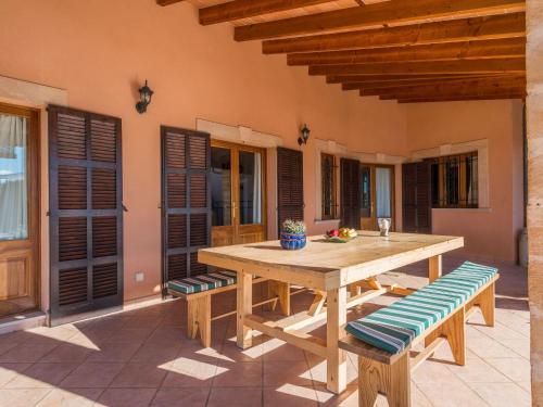 une table en bois et des bancs sur une terrasse dans l'établissement Buenos Aires - Villa With Private Pool In Manacor Free Wifi, à Manacor